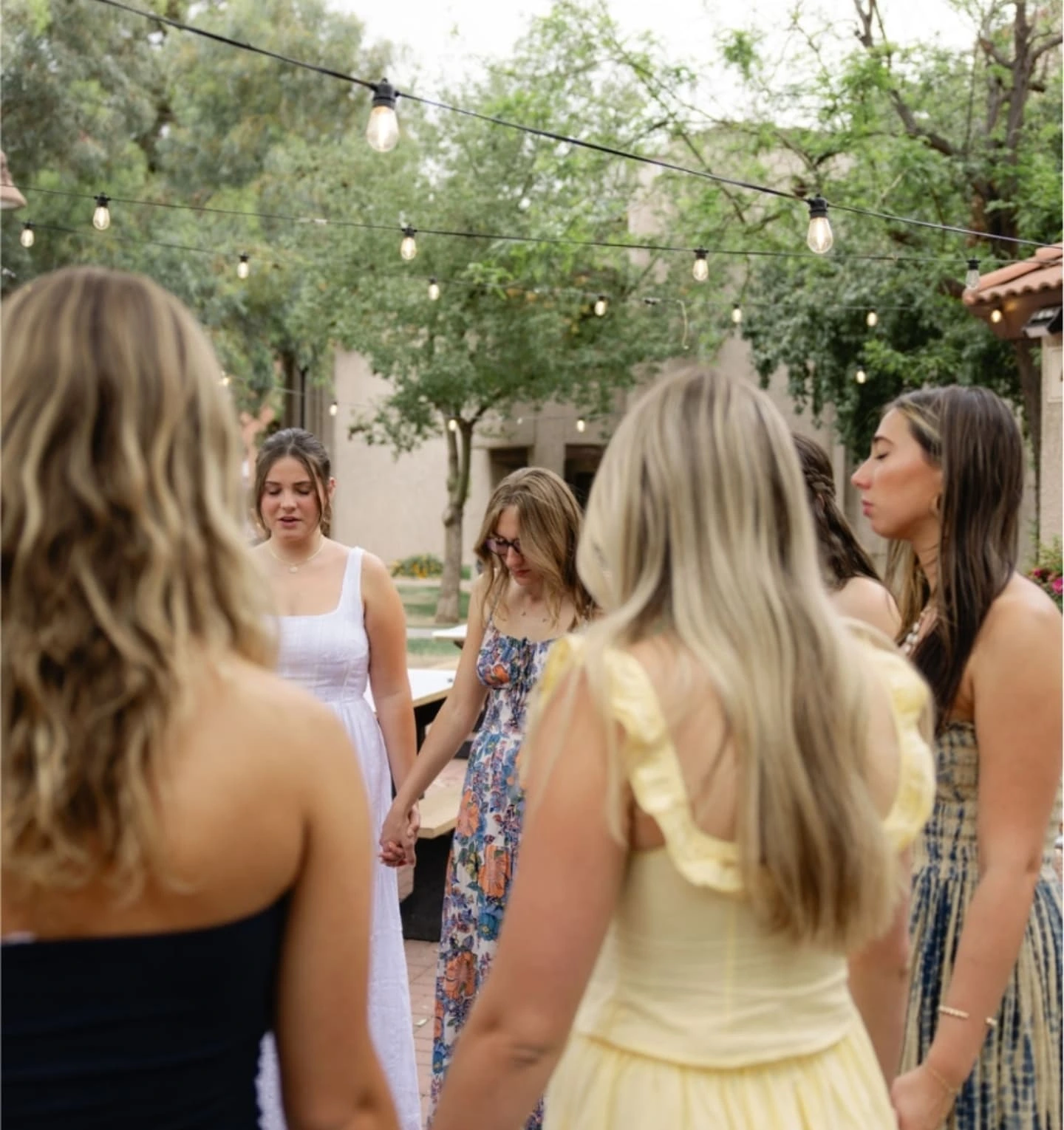 Women holding hands together outdoors at an Ezer event