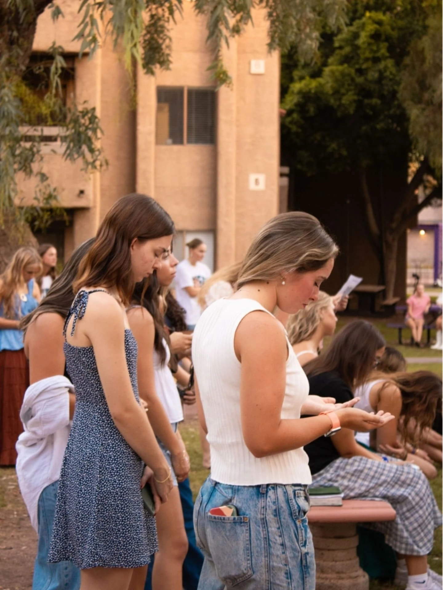 Women gathering outdoors for prayer at an Ezer event