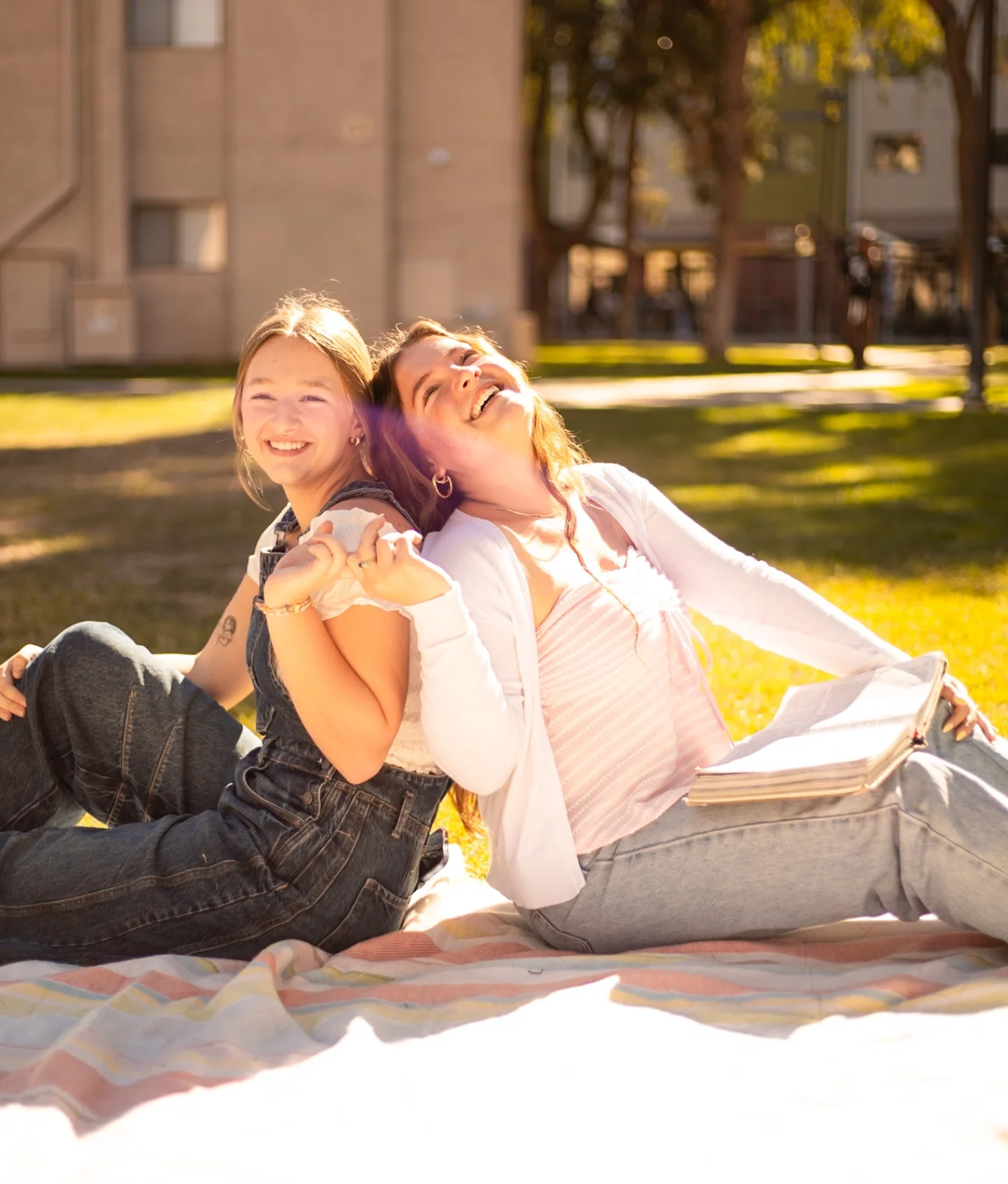Two women laughing together during a campus picnic